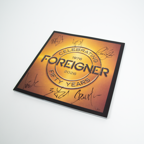 The front cover of the Foreigner Tour Book featuring a gold-to-orange gradient design with the text 'Celebrating Foreigner 1976 2026 Fifty Years' and multiple black autograph signatures by the members around the border, 